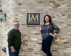 Michelle and Gil in front of J&M sign.